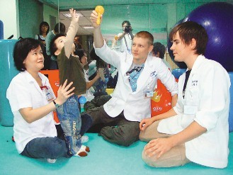 來自芬蘭的羅伊（右二）、米格（右一）到陽明大學附設醫院學習，昨天跟著物理治療師王雅嫻協助幼童「小益」復健。
記者羅建旺／攝影
